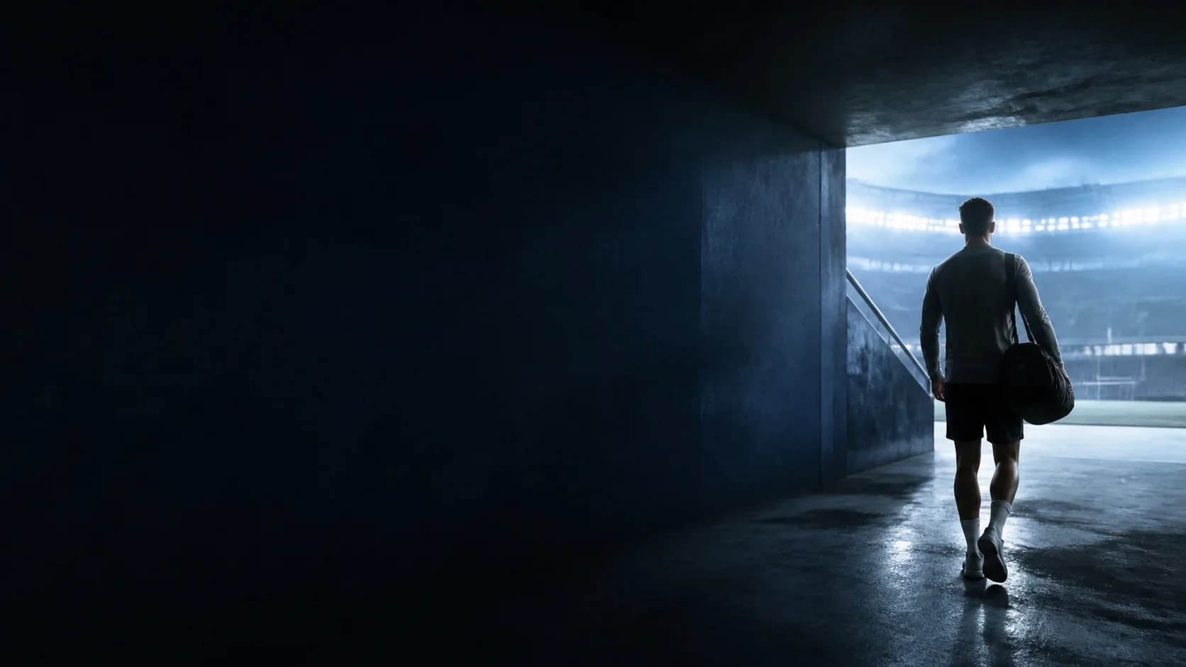 An athlete walking from the stadium tunnel toward the field